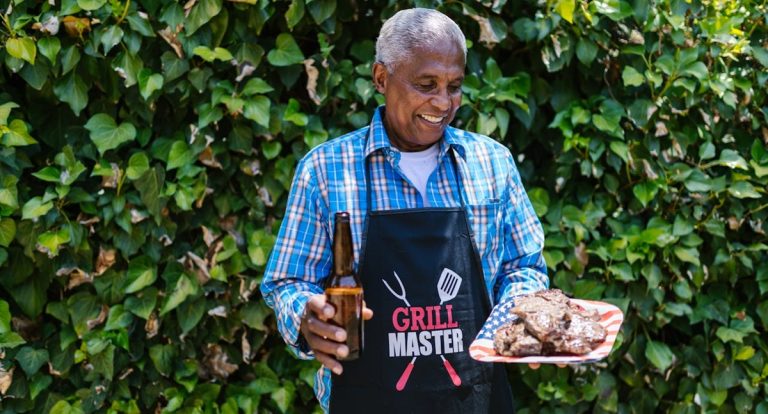 senior citizen grill master with a plate of meat